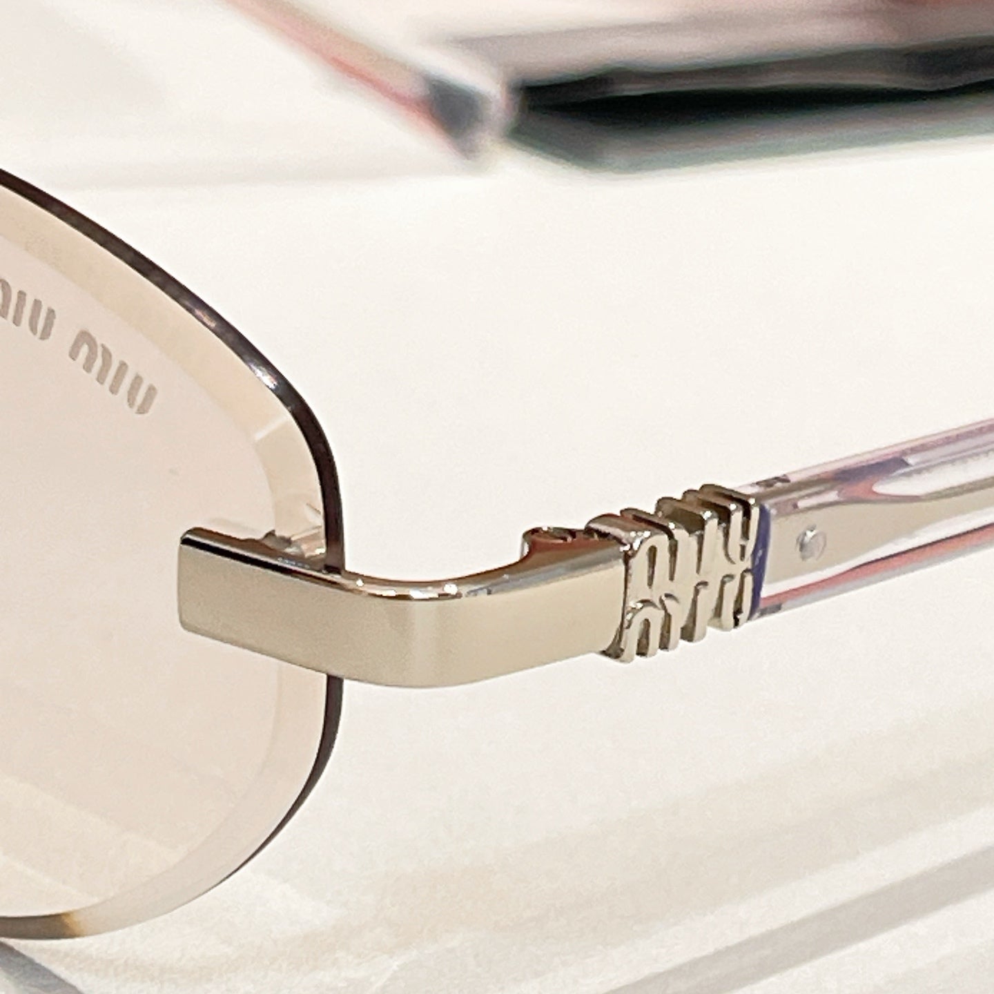 Round sunglasses close-up: gold-tone hinge and curved temple arm
