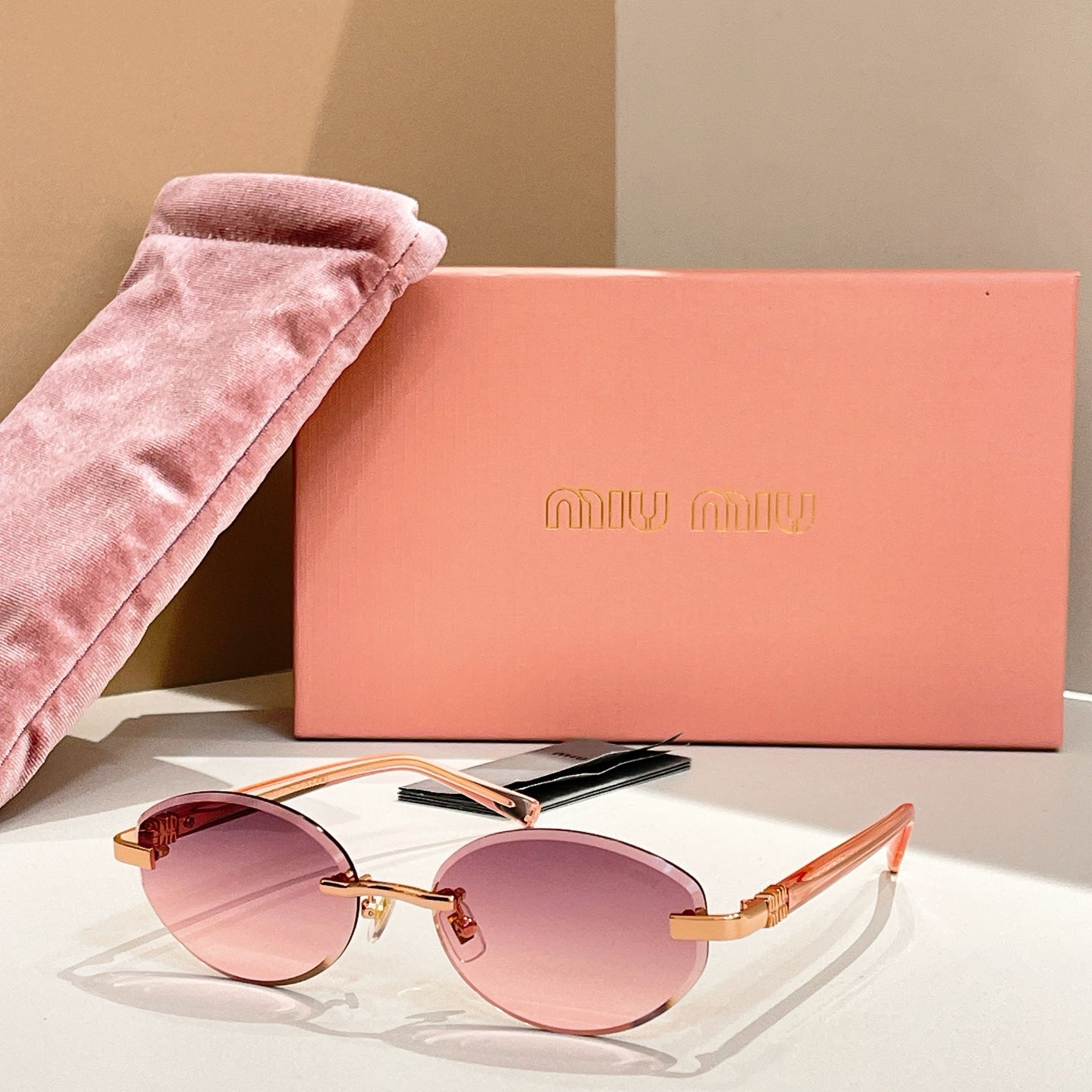 Round sunglasses with pink-tinted lenses and gold-tone frames, rose arms