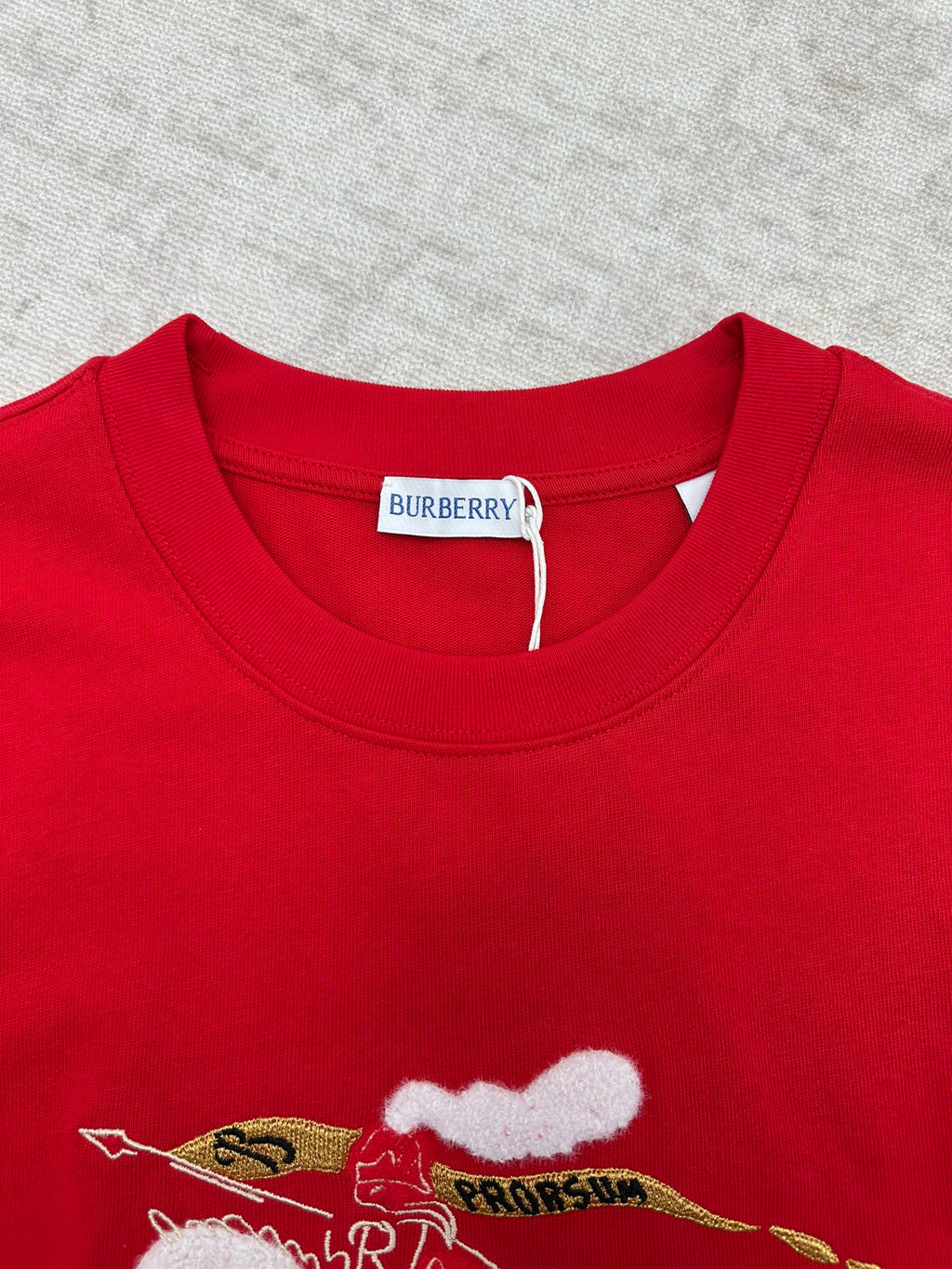 Red crew-neck T-shirt with embroidered-style cat graphic at chest