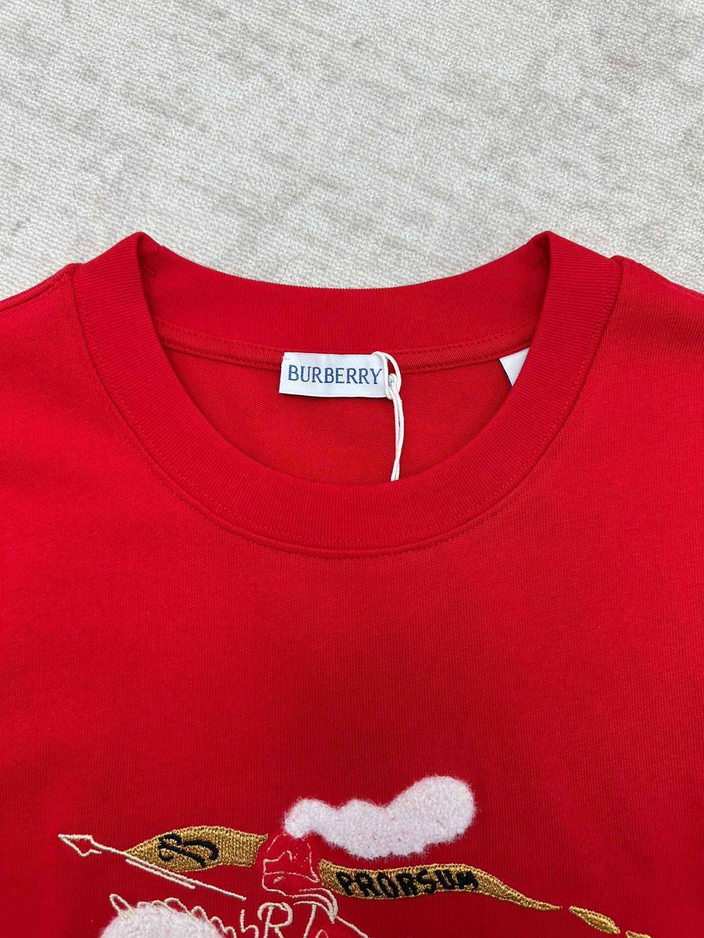 Red crew-neck T-shirt with embroidered-style cat graphic at chest