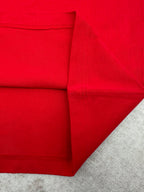 Red T-shirt folded view showing side panel and stitched seams