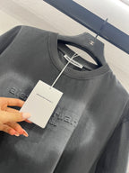 Dark gray crew-neck T-shirt neckline with inner label and partial chest print