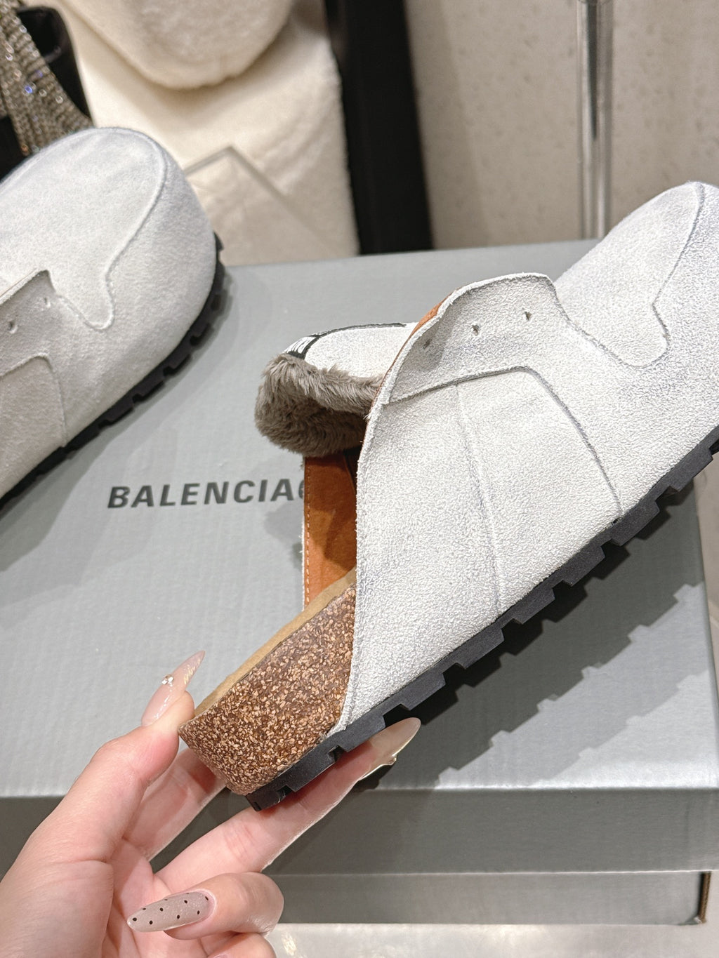 Balenciaga white slide sandals, side view showing black tread and brown speckle