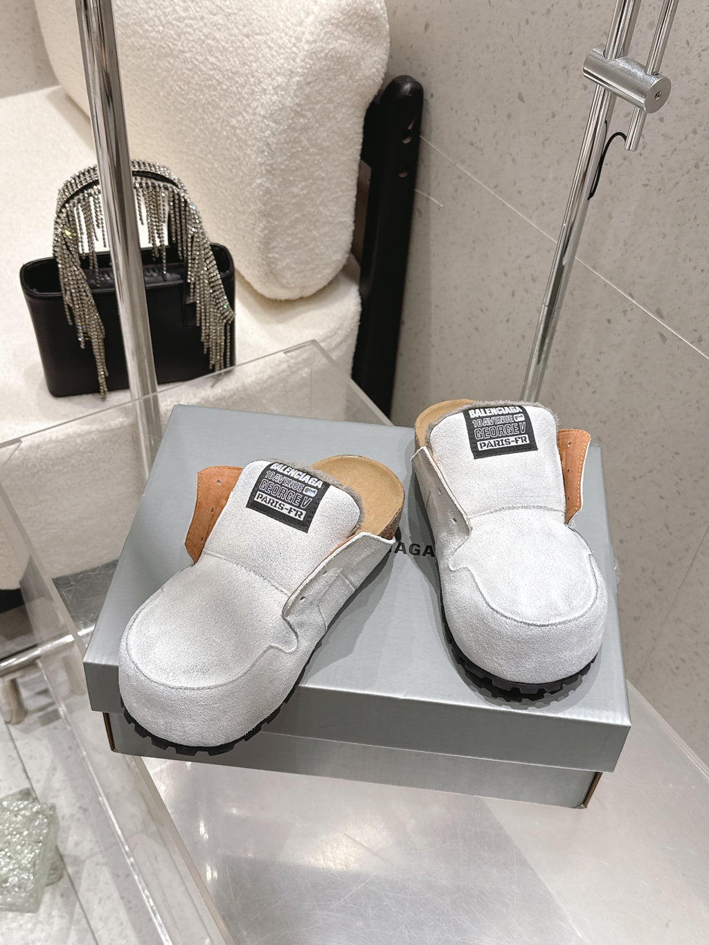 Balenciaga white slide sandals on box, tan heel lining and black outsole