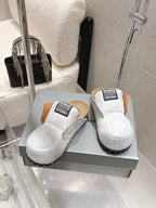 Balenciaga white slide sandals on box, tan heel lining and black outsole