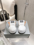 Balenciaga white slide sandals with black tread sole and logo strap