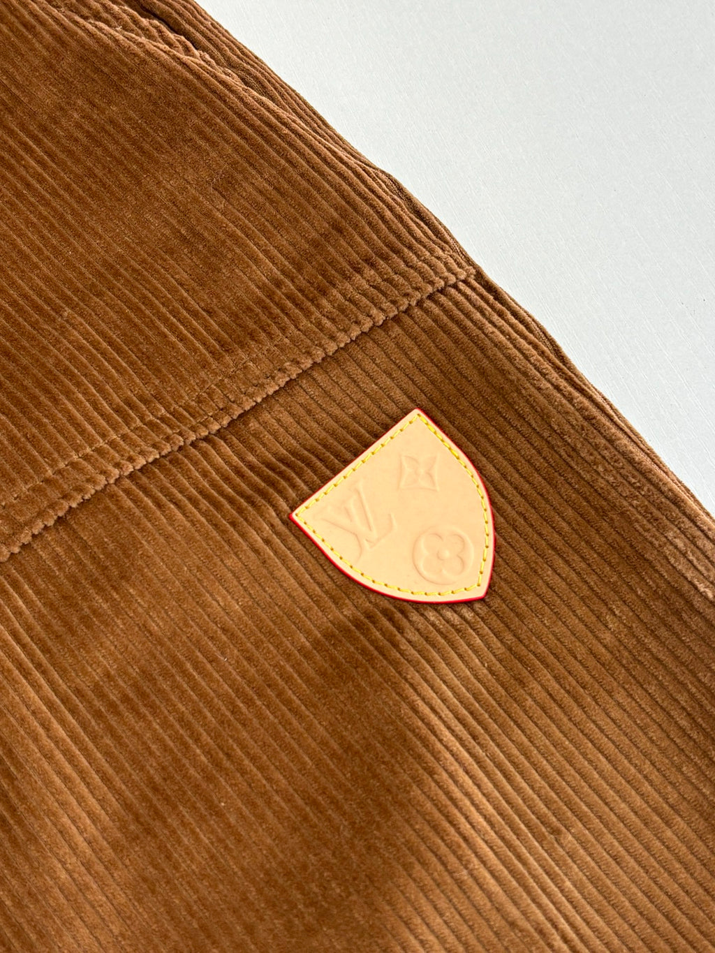 Louis Vuitton brown corduroy pants with triangle logo patch on the side