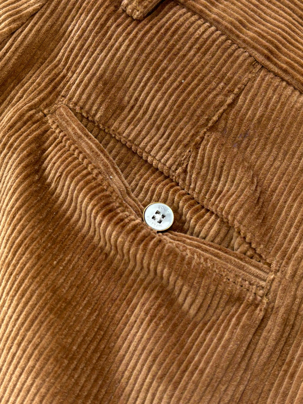 Corduroy pants detail: round button and welt pocket