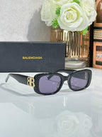 Sunglasses with black frames and purple lenses, gold logo detail on temples