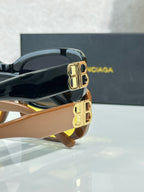 Sunglasses temple view with gold logo hardware on dark frames