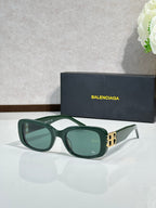 Sunglasses with dark green frames, green lenses, and gold logo hardware