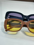 Sunglasses with brown frames and amber lenses, gold logo hardware detail