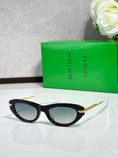 Cat-eye sunglasses with black frame and gold temples, tinted lenses