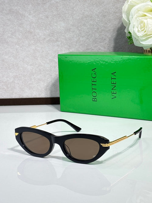 Cat-eye sunglasses with black frame and gold temples, dark tinted lenses