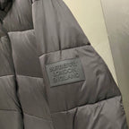 Puffer jacket back with logo patch, dark gray quilted sections and stitched panel seams.
