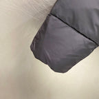 Puffer jacket sleeve cuff detail with dark gray fabric and stitched hem fold.
