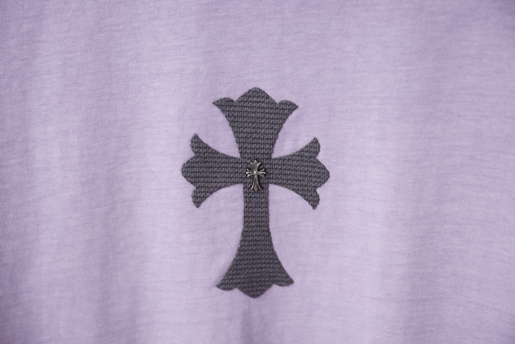 Lavender T-shirt front with dark cross patch and small gold accents