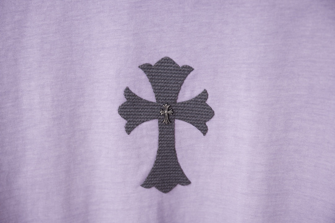 Lavender T-shirt front with dark cross patch and small gold accents