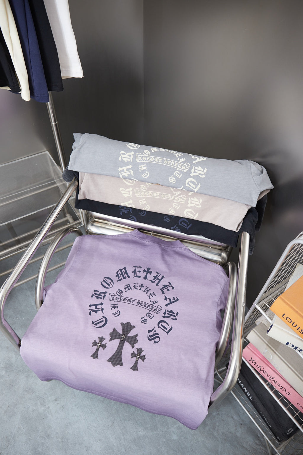 Folded lavender short-sleeve T-shirts with dark cross emblem and text print