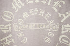 Light gray T-shirt back print with decorative gothic lettering motif.