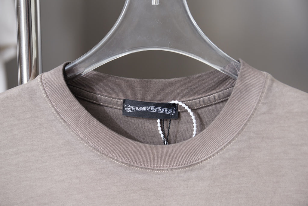 Light gray T-shirt close-up with round ribbed collar and neck tag.