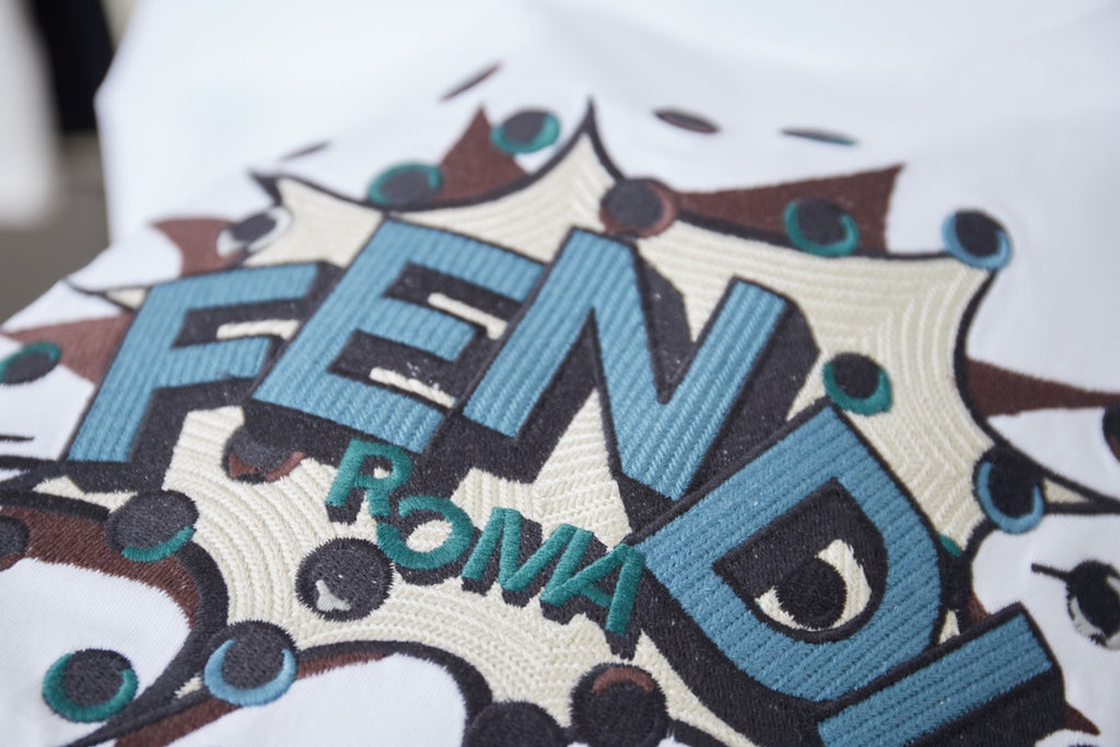 Fendi logo graphic close-up on white T-shirt, blue FENDI lettering