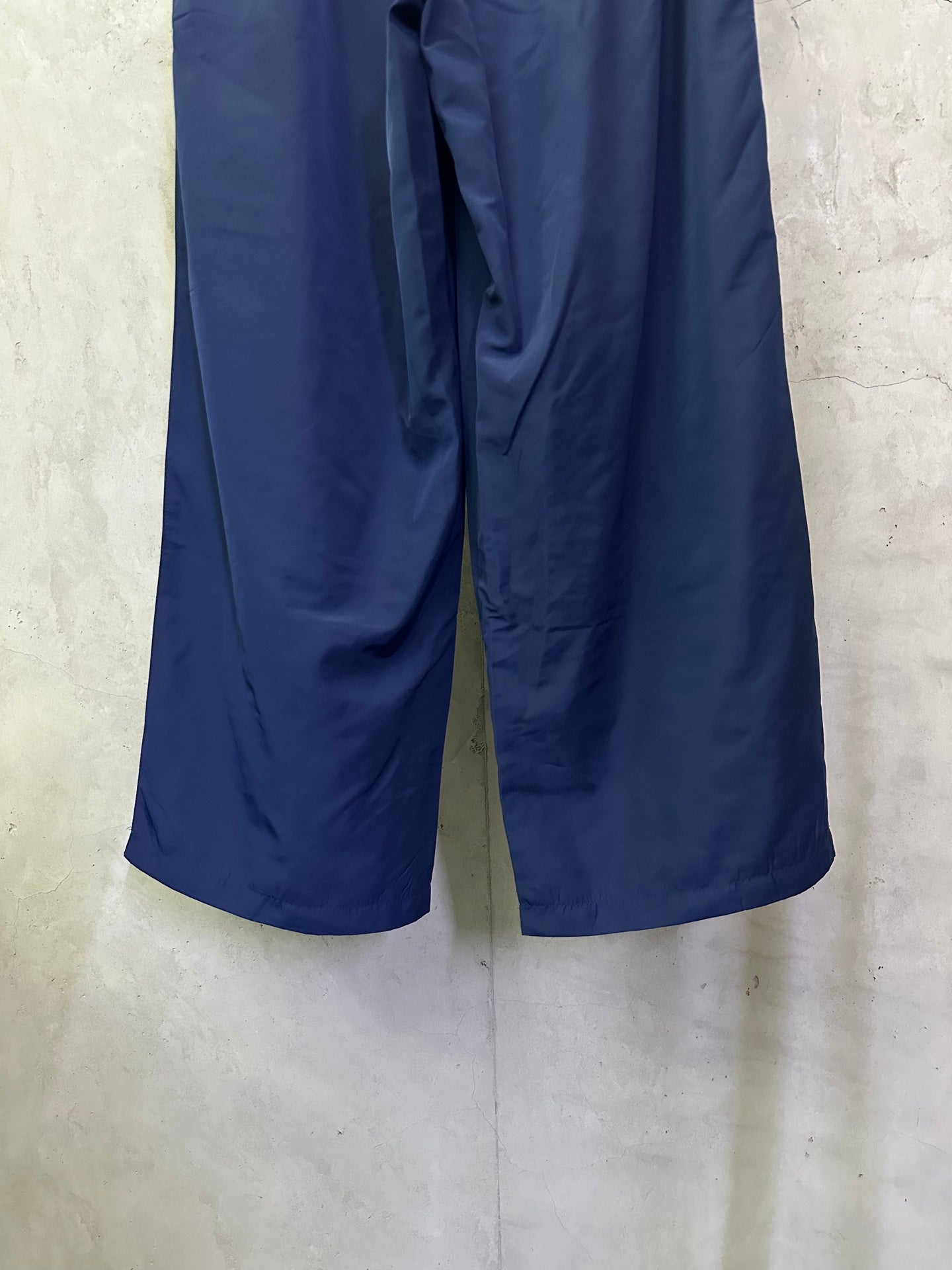 Blue wide-leg drawstring pants with front seam and draped fabric
