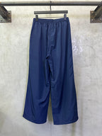 Blue wide-leg drawstring pants, side view with relaxed drape