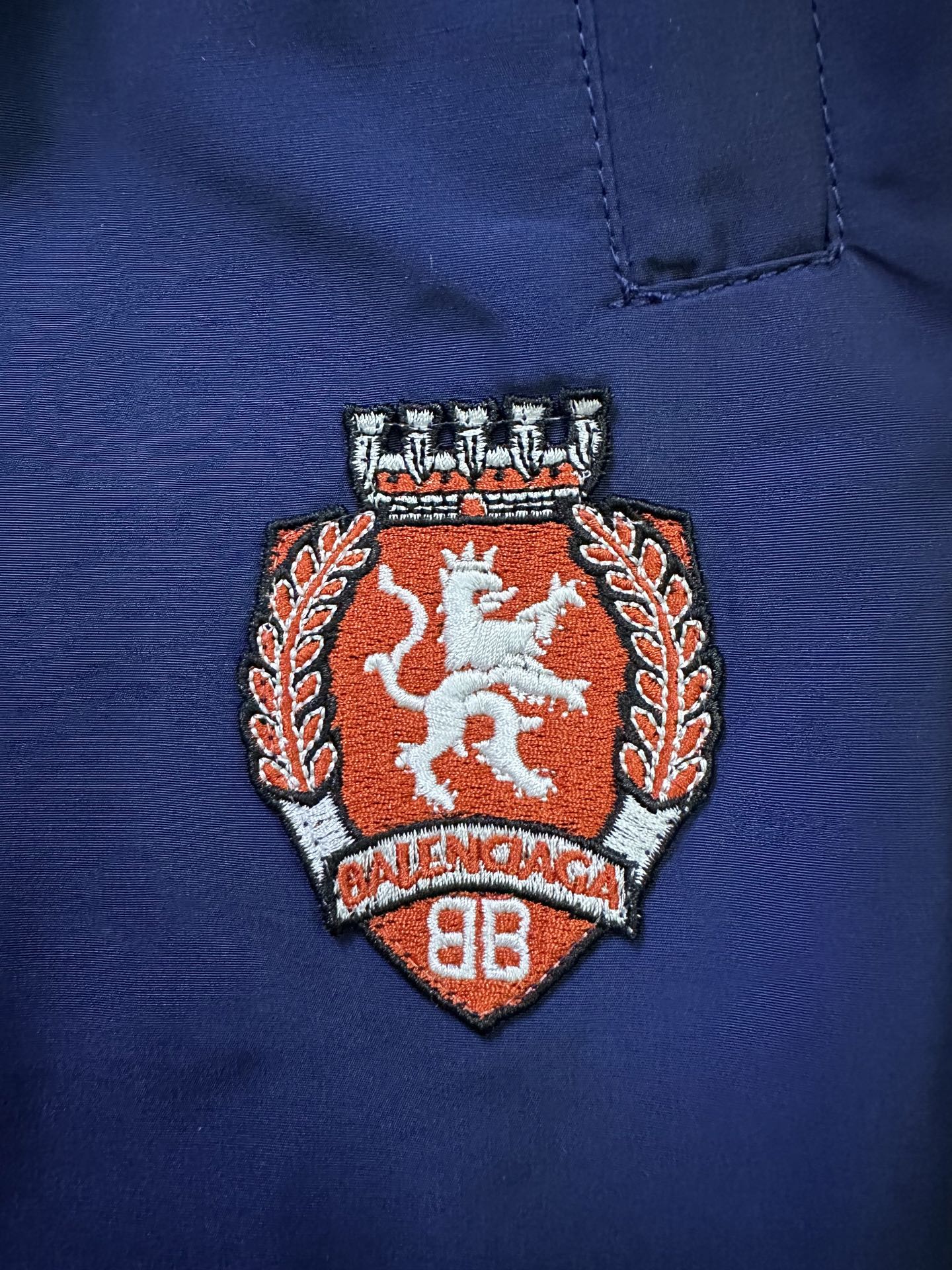 Blue pants with embroidered Balenciaga crest patch on right leg