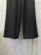 Balenciaga black wide-leg pants, front view of relaxed leg opening