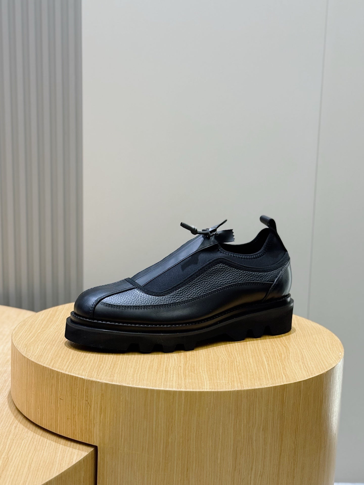 Lace-up leather shoe in dark finish with textured upper and thick cushioned sole, side view
