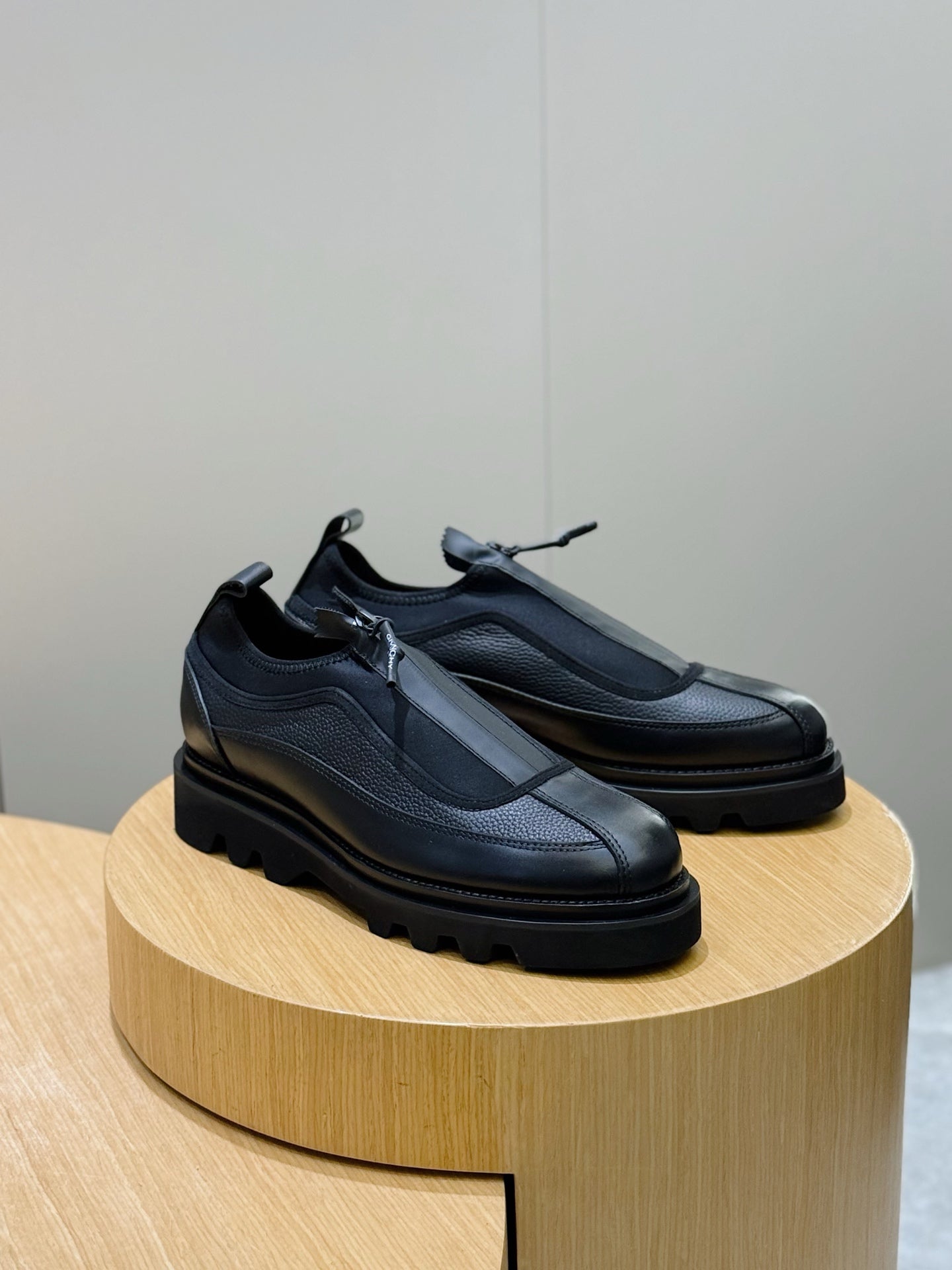 Lace-up leather shoes with dark upper panels and chunky sole, angled view