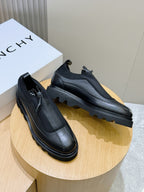 Pair of lace-up leather shoes on display, dark uppers with lace-up detailing and chunky soles