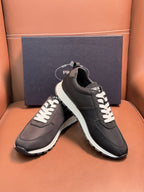 Black Prada sneakers on box, lace-up low tops with white laces and white edge sole