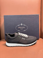 Black Prada sneakers on box, low-top lace-up with white laces and white rubber sole
