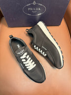 Black Prada sneakers, side view, lace-up with white laces and chunky tread sole