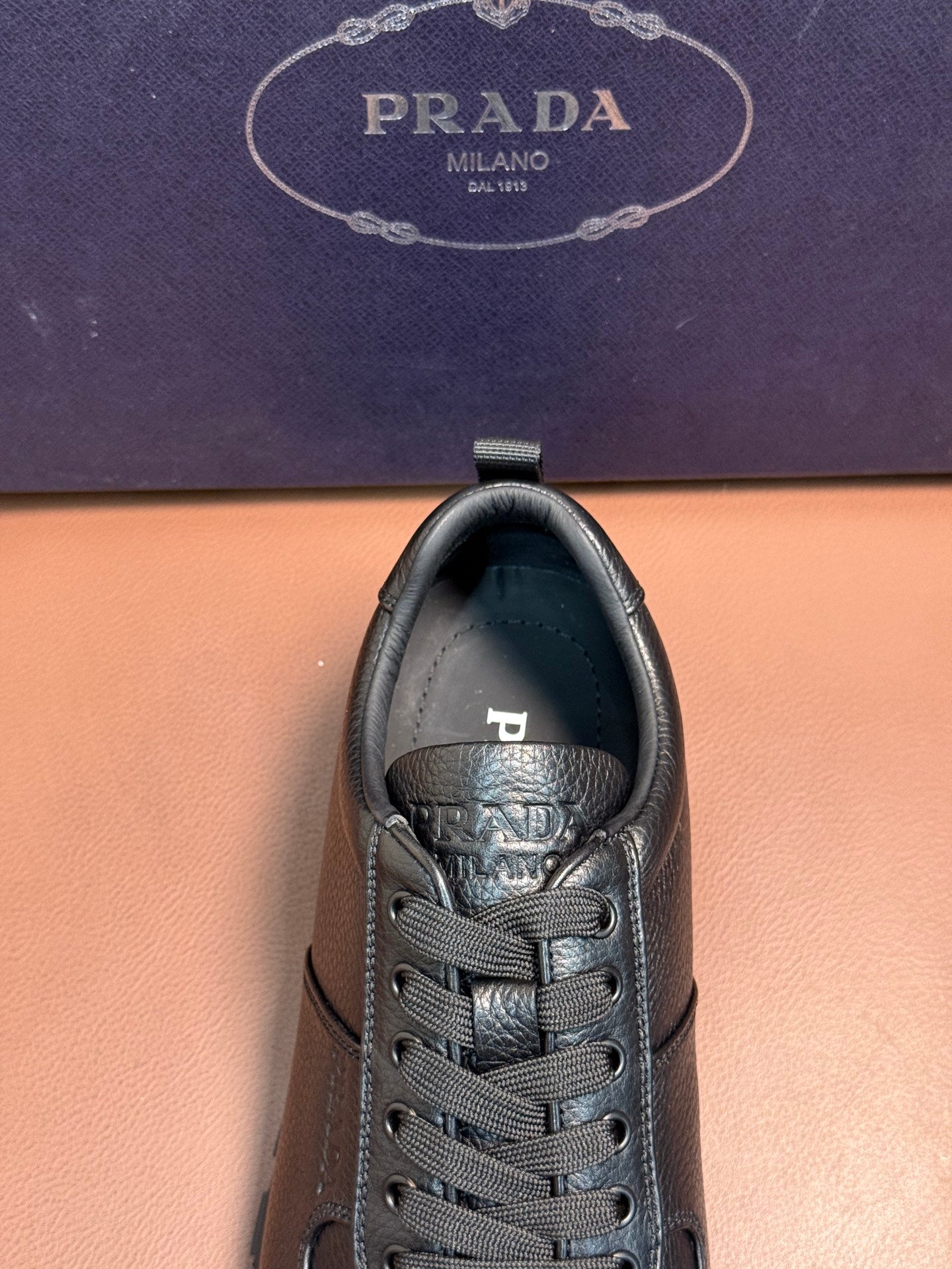 Dark leather lace-up sneaker heel and tongue view with branding detail