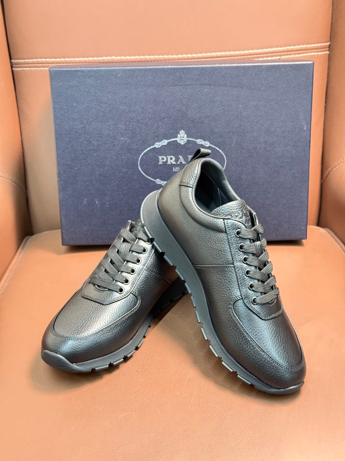 Silver leather lace-up sneakers on a display, showing lace-up and thick sole