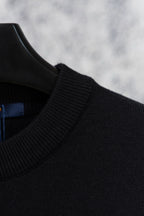 Black knit sweater shoulder and neckline with ribbed collar detail