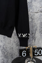 Black sweater sleeve with ribbed cuff and white LV monogram trim