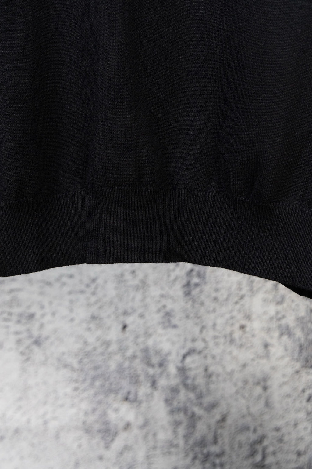 Black knit sweater hem with ribbed cuffs, plain knit texture