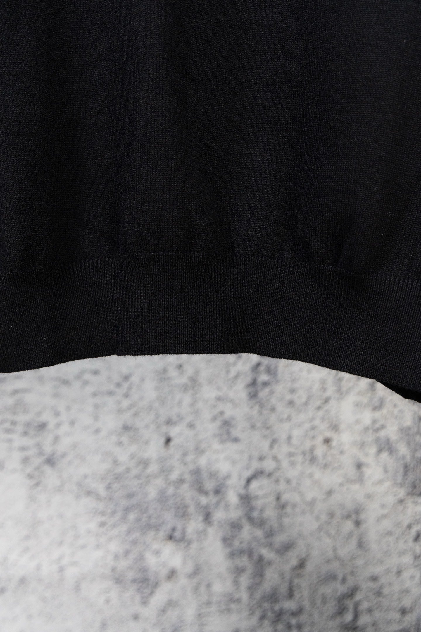 Black knit sweater hem with ribbed cuffs, plain knit texture