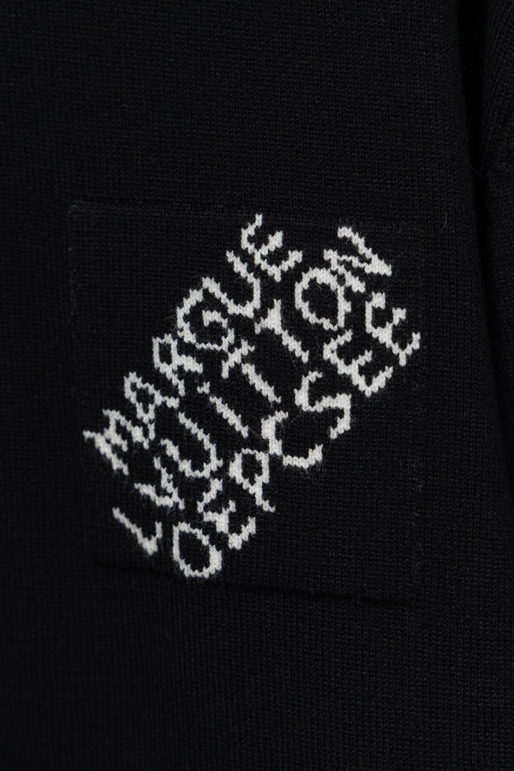Black knit sweater fabric with white embroidered logo pattern