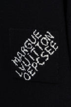 Black knit sweater fabric with white embroidered logo pattern