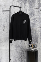 Black knit sweater with crew neck and small white logo detail at chest