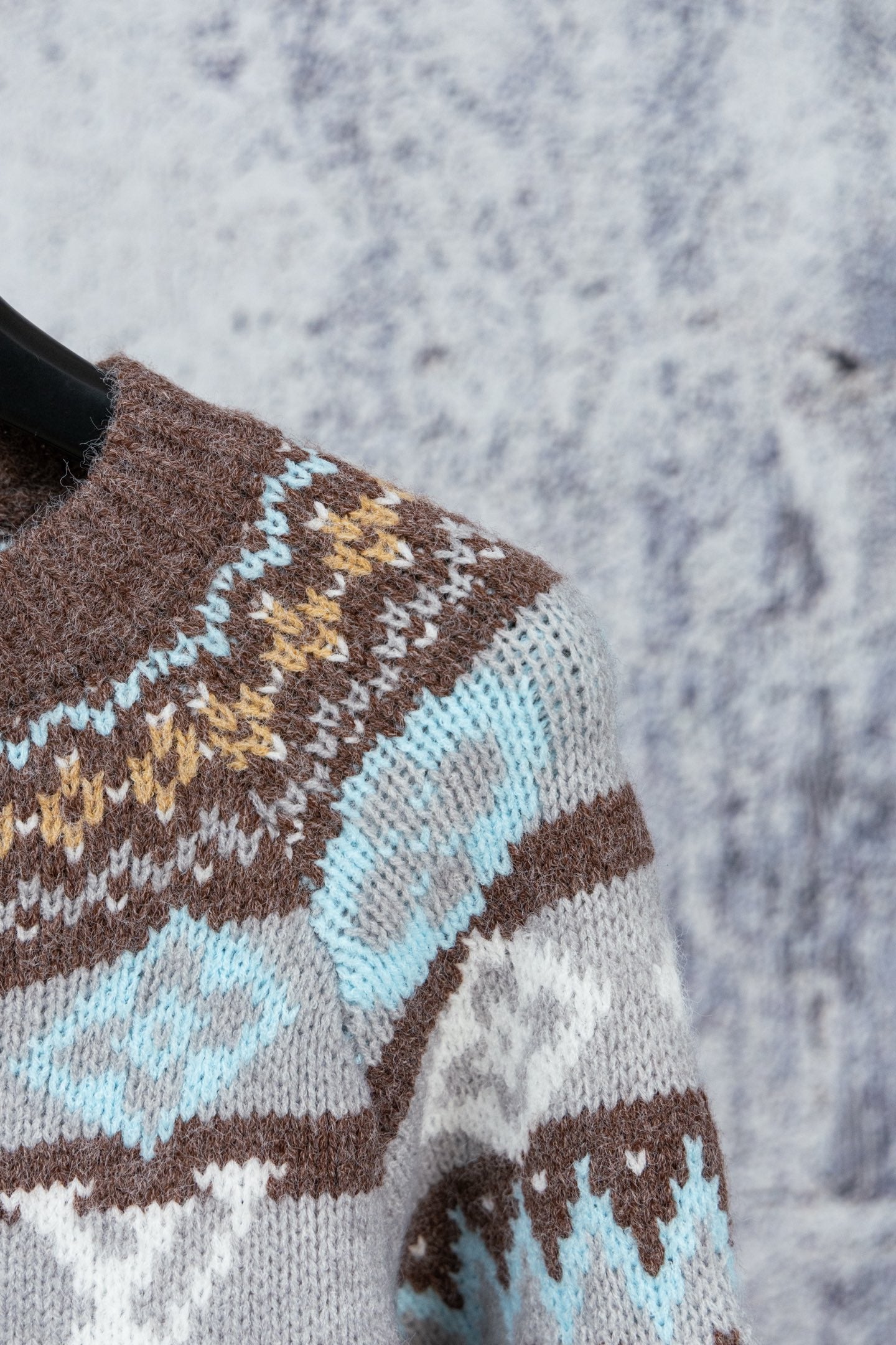 Brown knit sweater sleeve with blue, cream and tan Fair Isle stripe