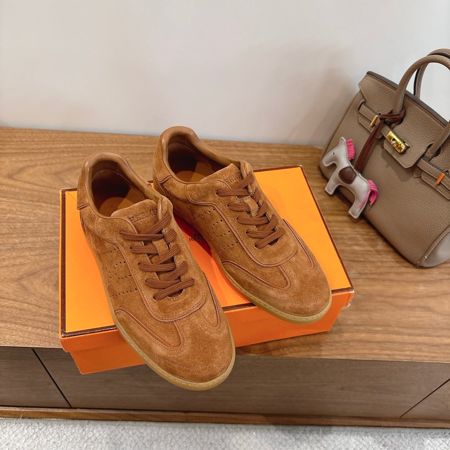 Suede lace-up sneakers in tan, viewed from above with textured panels and stitching