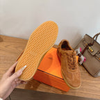 Tan suede sneaker with lace-up front and patterned outsole, shown from side and bottom