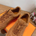 Tan suede sneakers with lace-up detail and visible perforated side panels