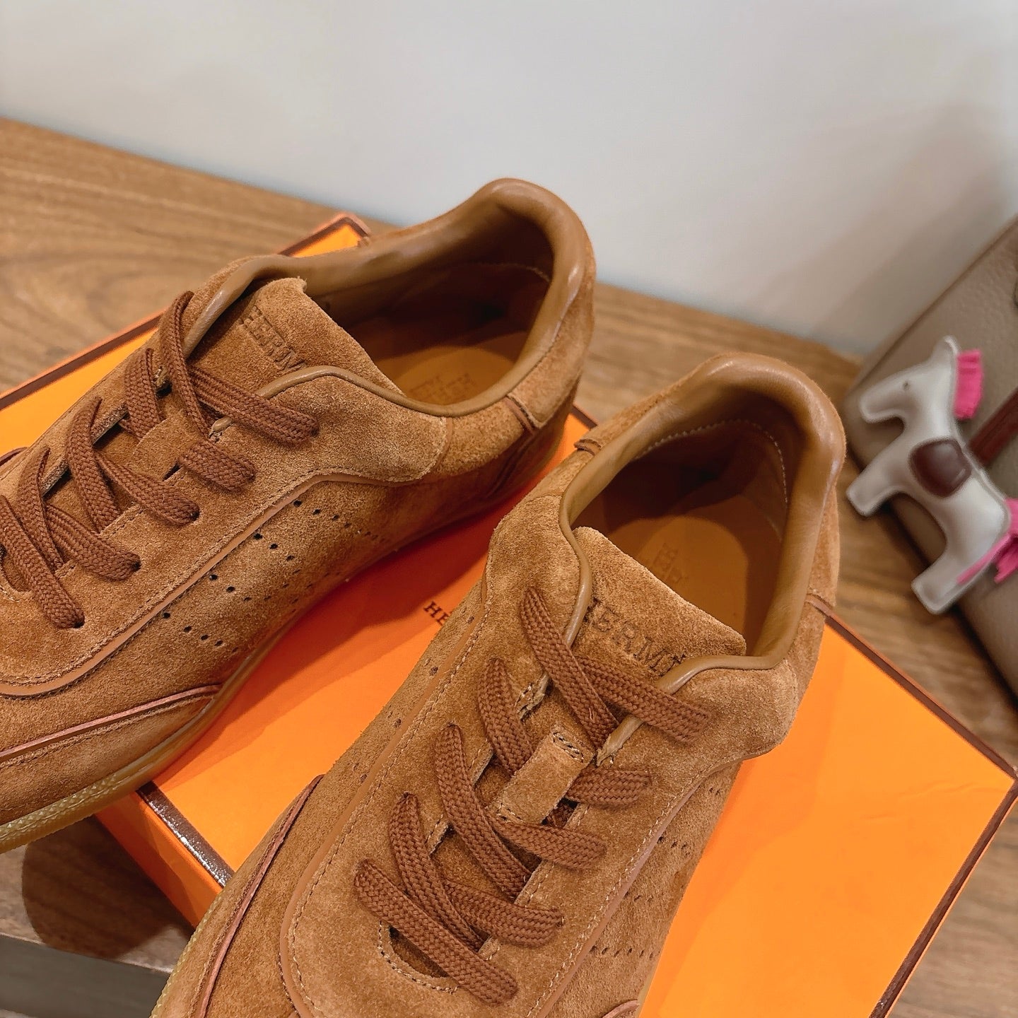 Tan suede sneakers with lace-up detail and visible perforated side panels